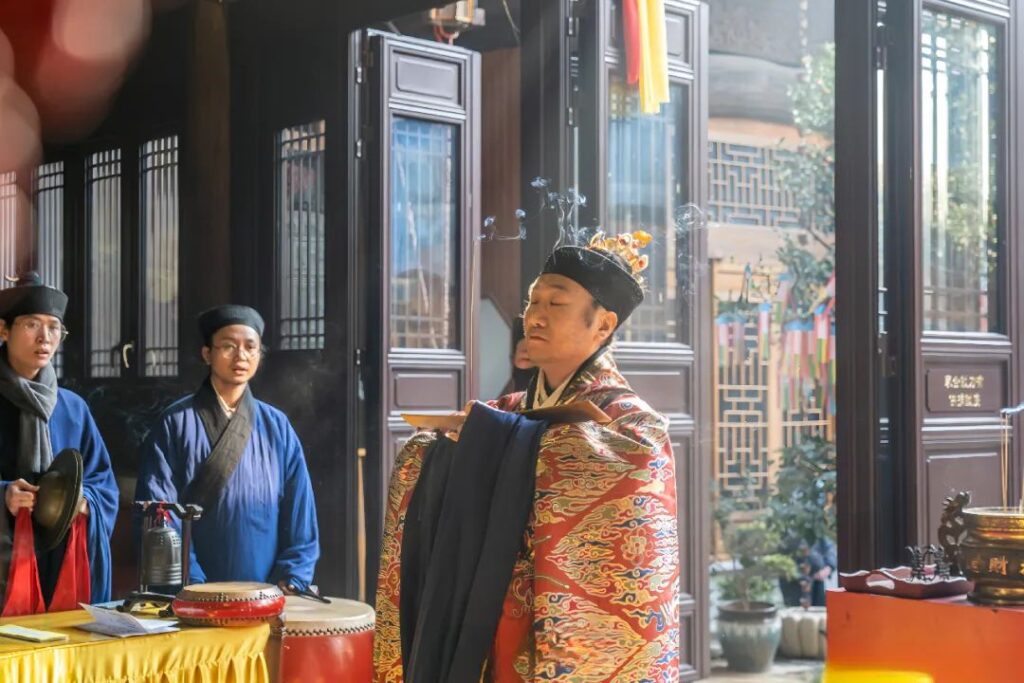 A Taoist priest is devoutly prostrating himself in worship